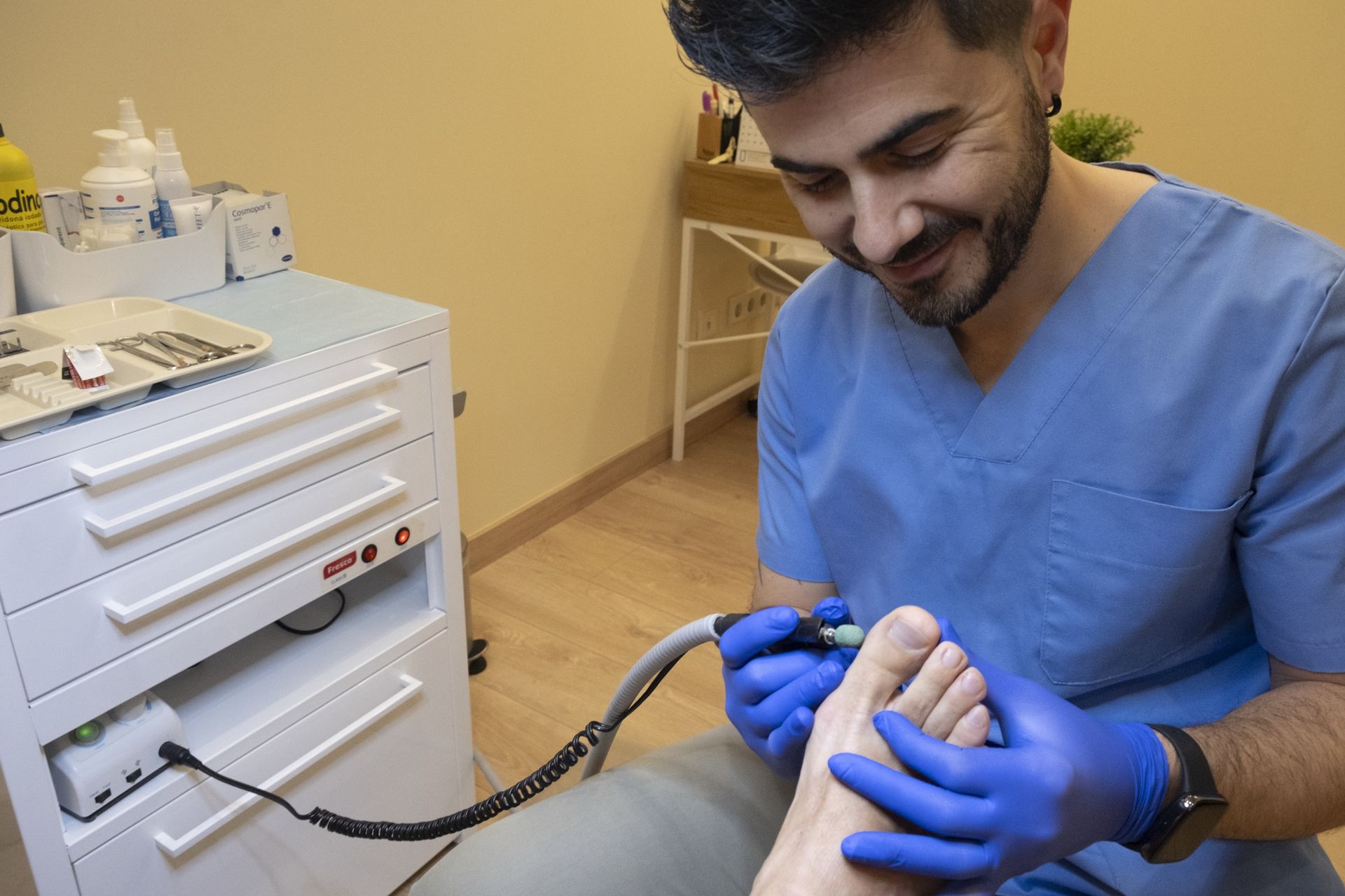Enrique Salinas, podólogo, tratando un pie con micromotor en Clínica Lebén