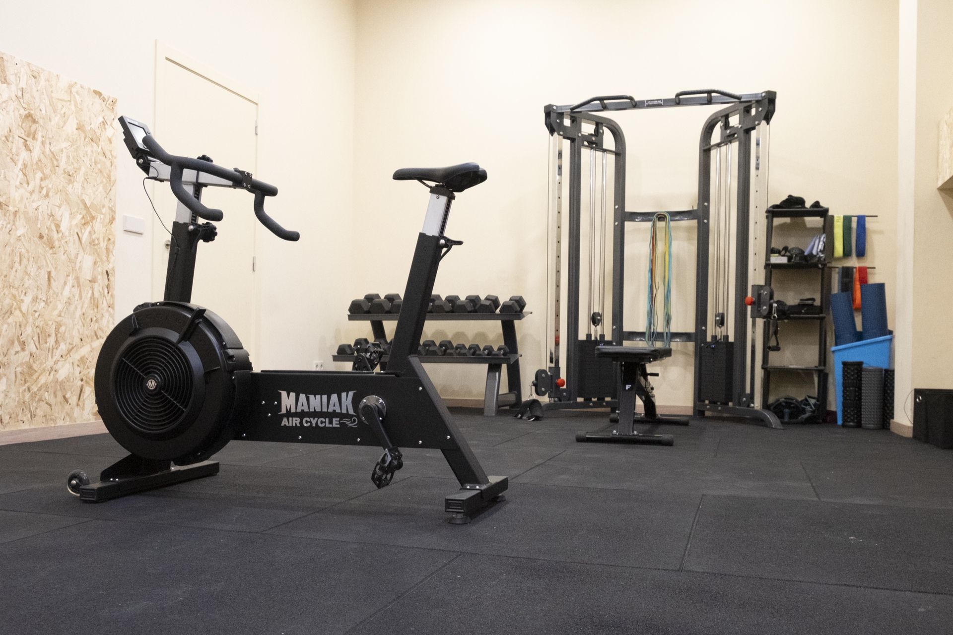 Sala de entrenamiento de Clínica Lebén con bicicleta de aire, mancuernas, máquina de poleas y material de ejercicio